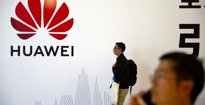 Pria Berlalu Lalang di depan Papan Iklan Huawei di Beijing, Tiongkok (China) Lisensi Usaha di AS