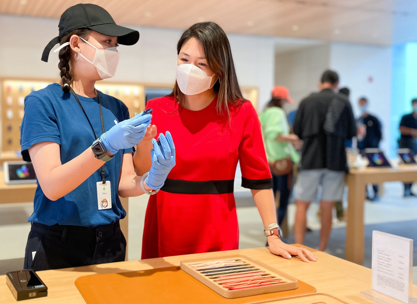 Apple spesialis menjelaskan produk kepada pelanggan di Store saat pandemi COVID-19